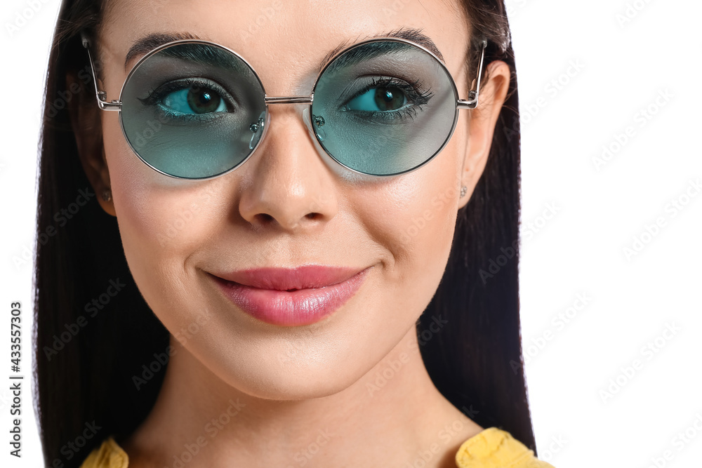 Beautiful young woman wearing stylish sunglasses on white background