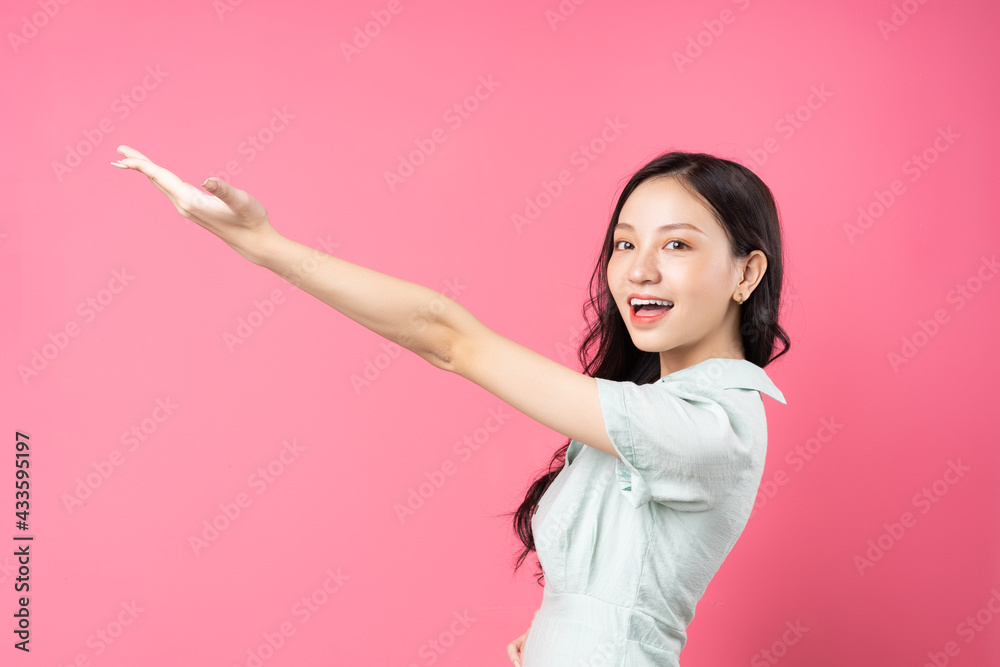 Young Asian woman pointing upwards with cheerful face