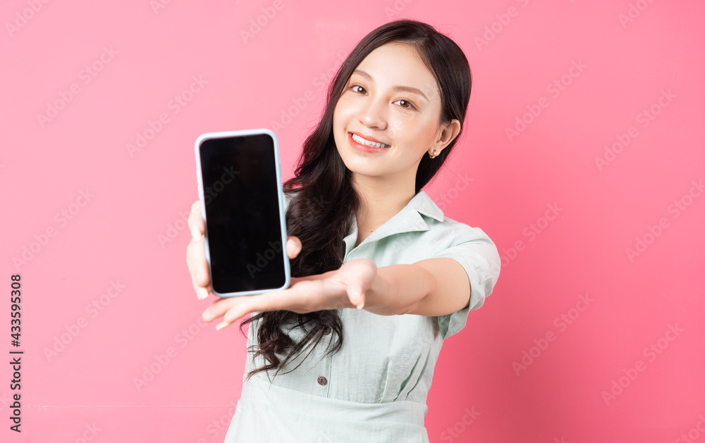 Young Asian woman holding phone in hand and holding it forward