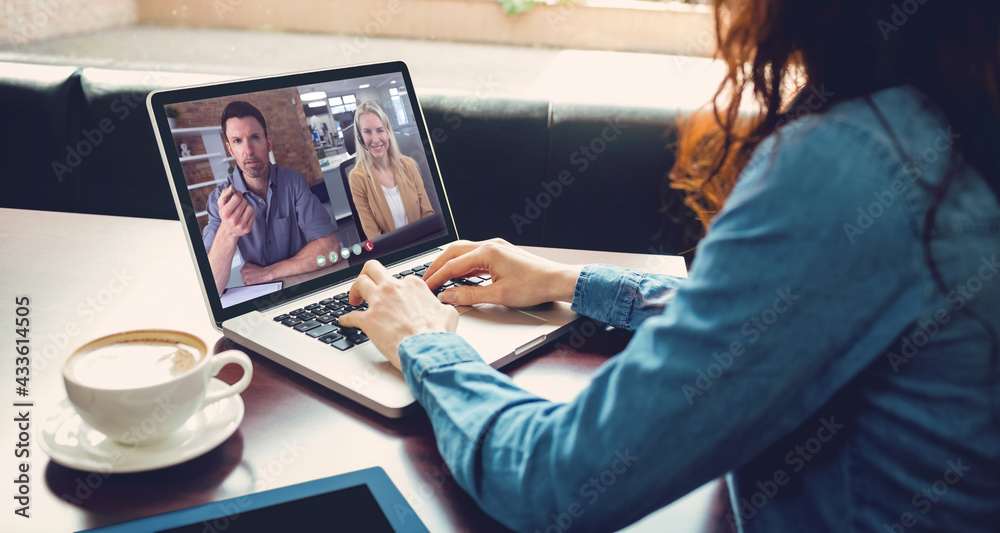 Caucasian businesswoman sitting at desk using laptop having video call with two colleagues