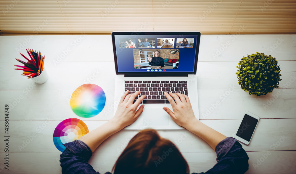 Caucasian businesswoman sitting at desk using laptop having video call with group of colleagues