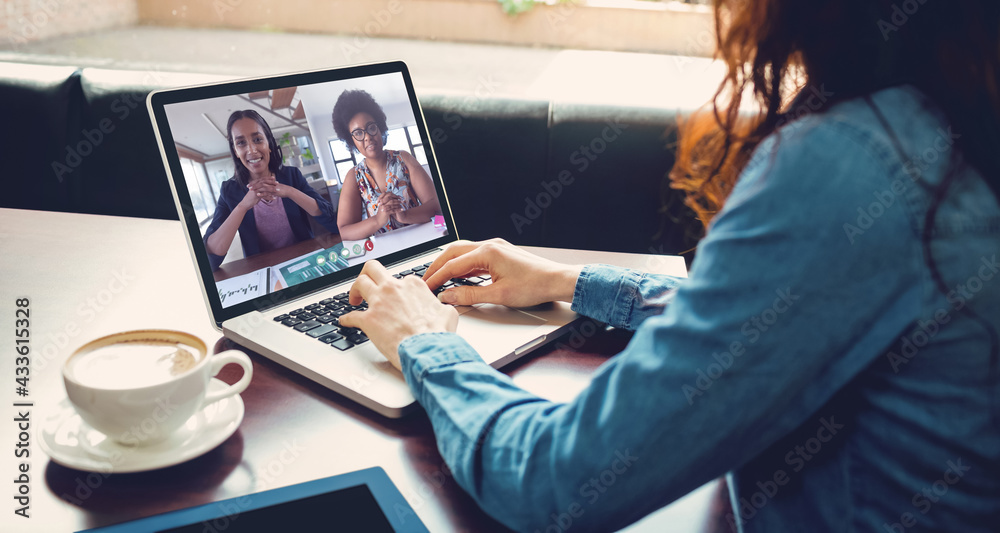 Caucasian woman sitting in cafe having video call with coworkers