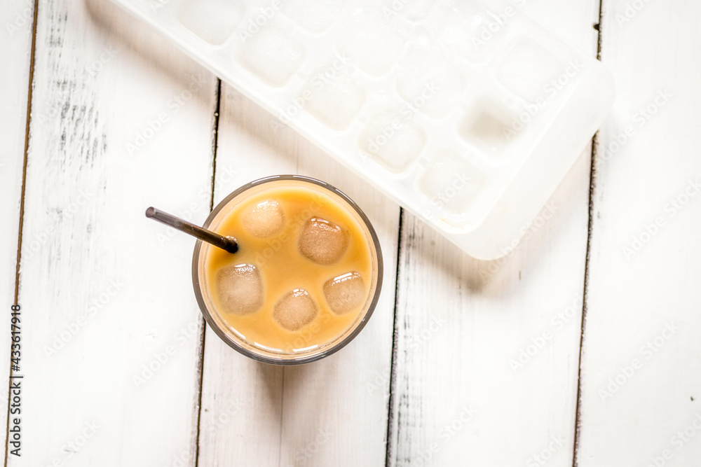 coffee break with cold iced latte and beans on white table background top view