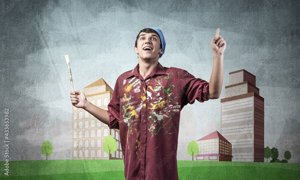 Young male artist holding paintbrush