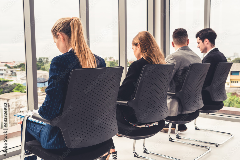 Businesswomen and businessmen waiting on chairs in office for job interview. Corporate business and 