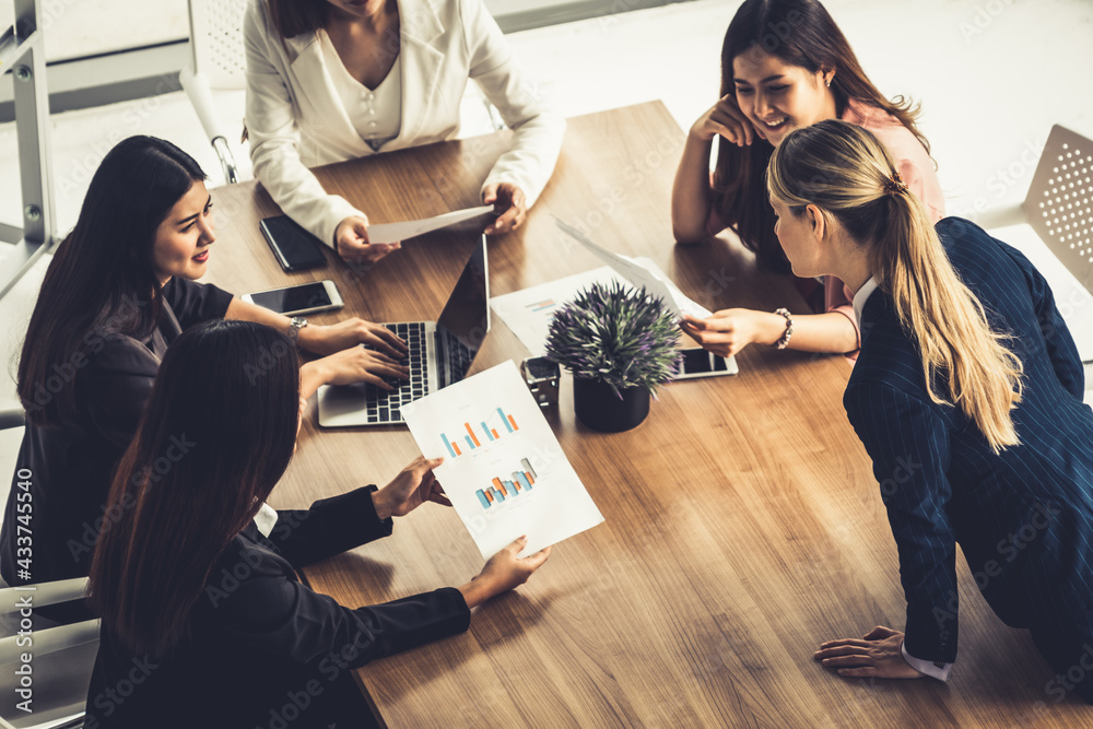 Businesswoman in group meeting discussion with other businesswomen colleagues in modern workplace of