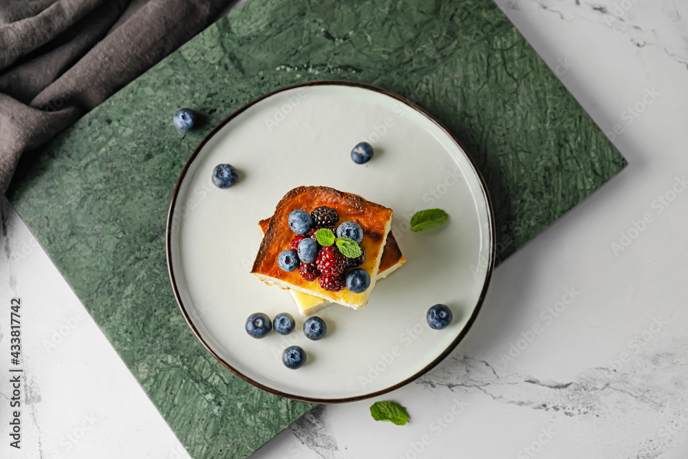 Plate with pieces of cottage cheese casserole on light background