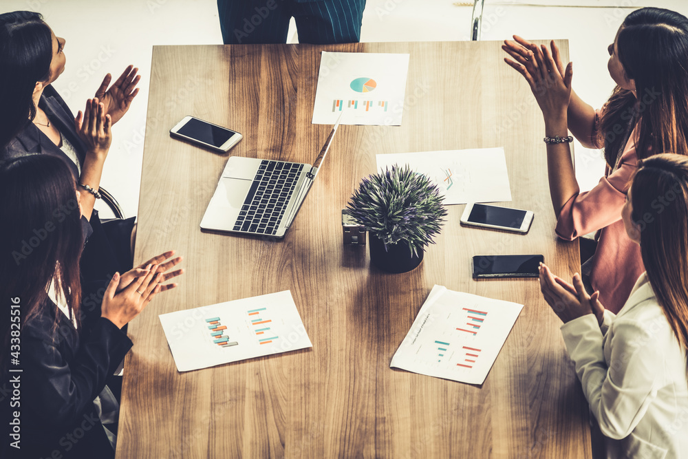 Businesswoman in group meeting discussion with other businesswomen colleagues in modern workplace of