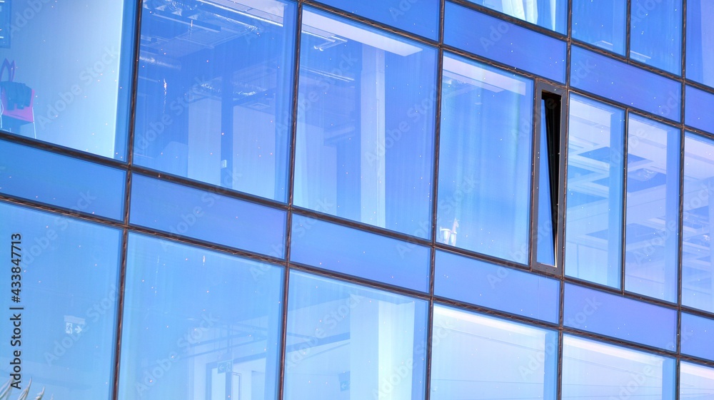 Mirrored windows of the facade of an office building. Abstract texture of blue glass modern office b