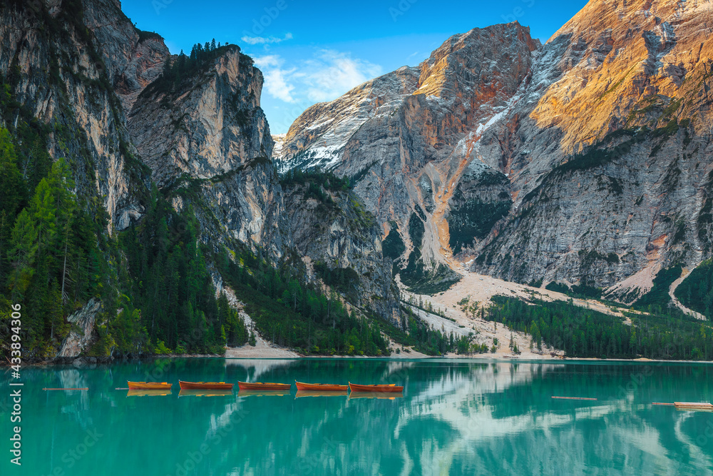 Anchored wooden rowing boats on the alpine lake, Dolomites, Italy