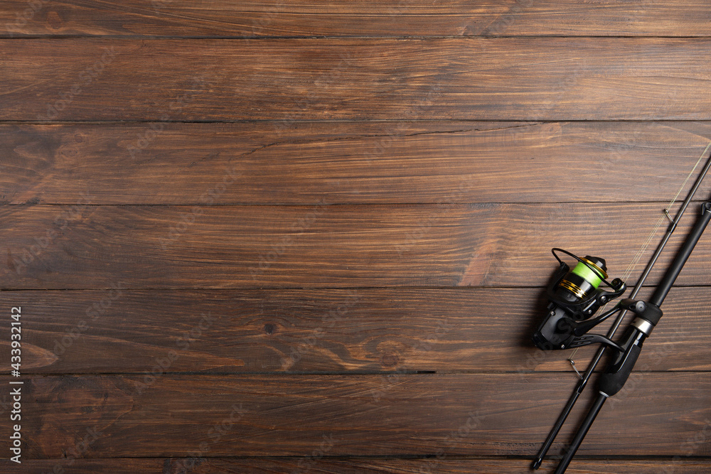 Fishing tackle - fishing spinning rod, hooks and lures on wooden background. Active hobby recreation