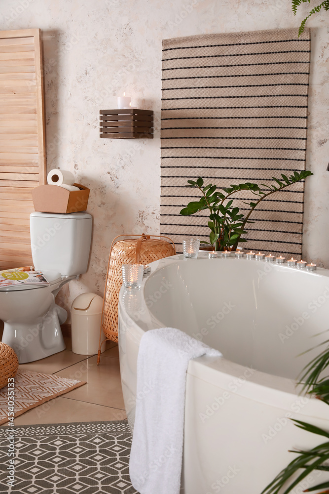 Stylish interior of modern bathroom with burning candles