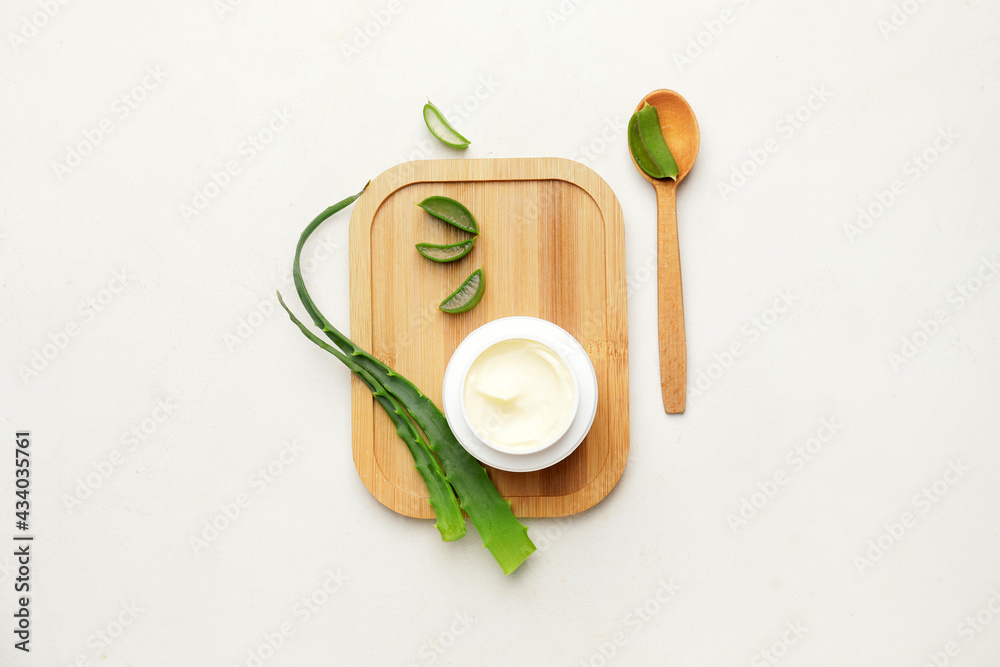 Natural cream with aloe leaves on light background