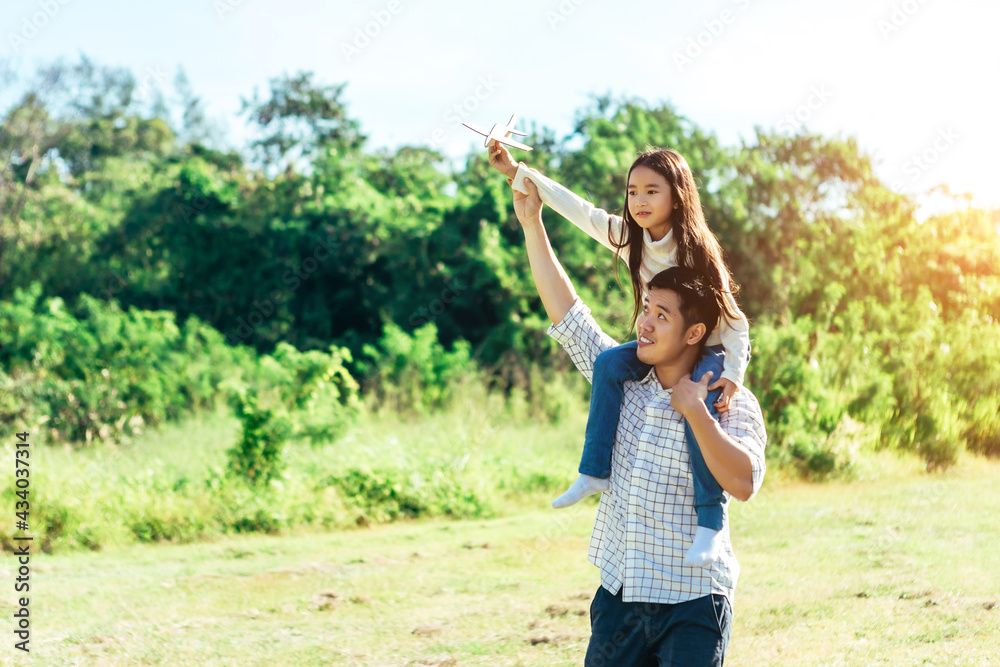 女儿坐在父亲的脖子上。一家人在美丽的自然中度过了一个假期。康塞普