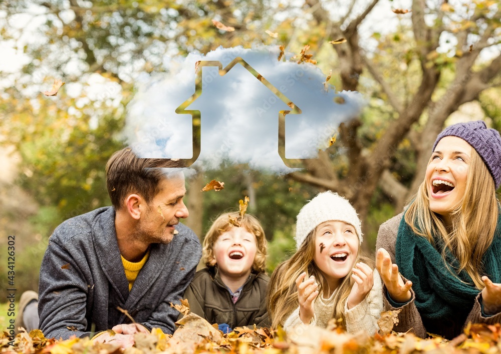 Composition of cloud with house icon over happy caucasian family in autumn park