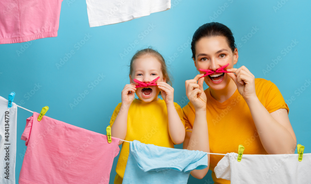 woman and girl hanging clothes on a rope