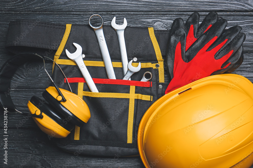 Bag with safety equipment on wooden background