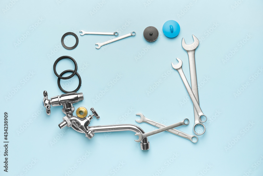 Frame made of plumbers items on color background