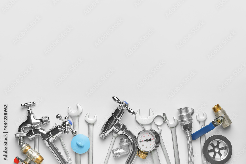 Set of plumbers items on light background