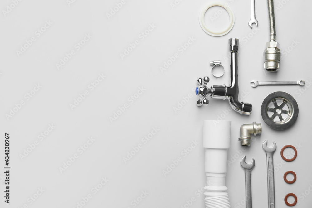 Set of plumbers items on light background