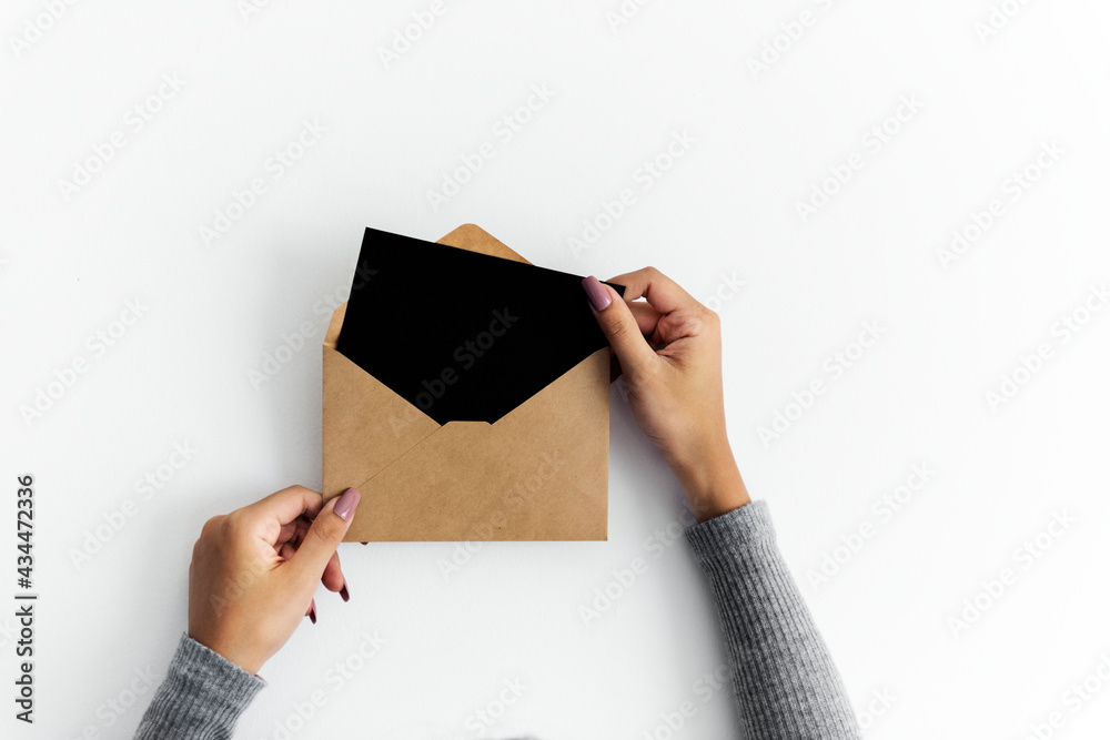 Woman hands holding envolope on white background