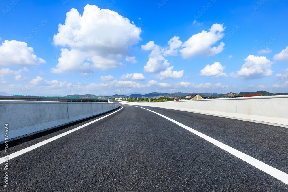 Country highway and blue sky with white clouds.