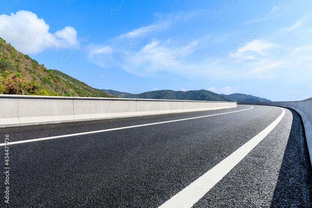 Mountain road landscape under blue sky.