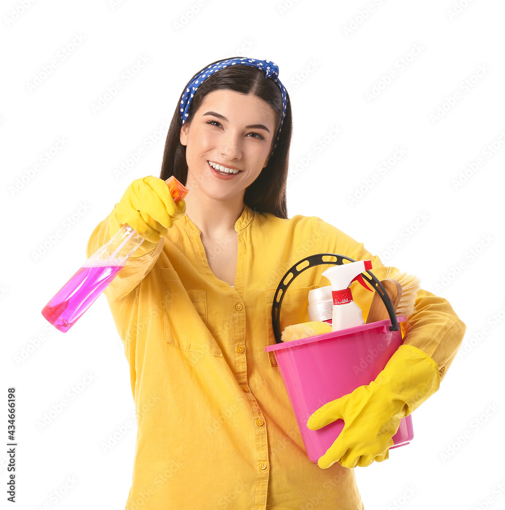 Young woman with cleaning supplies on white background