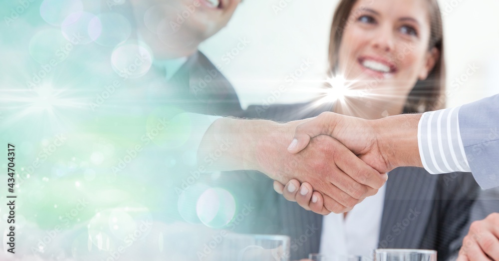 Composition of businessman handshake over smiling businesswoman and green spots of light