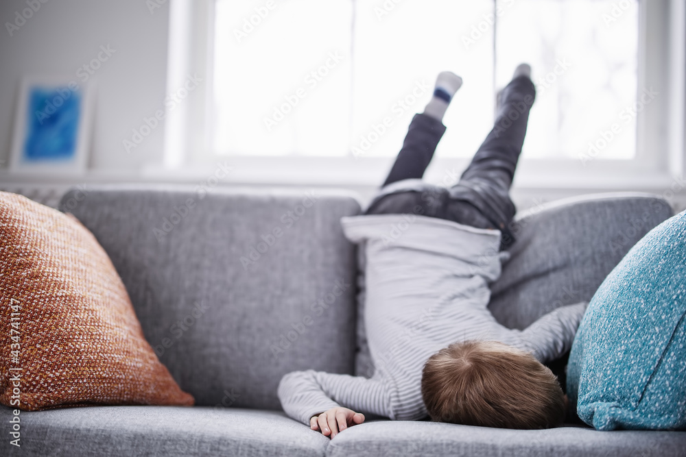 Cute child lying face down on the sofa