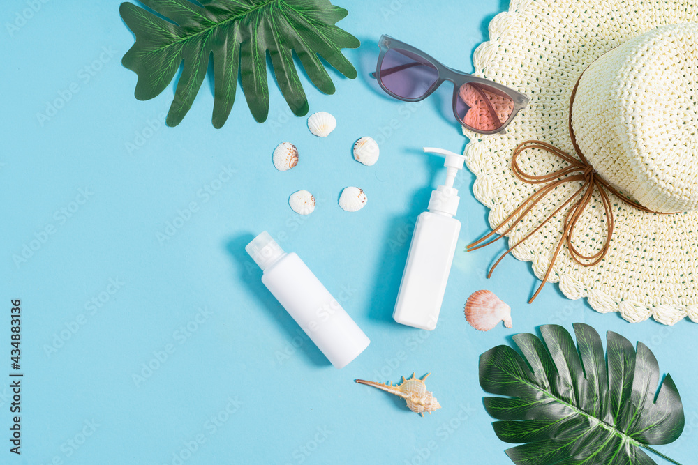 Two cosmetic jars displayed with seashells and hat on a blue background