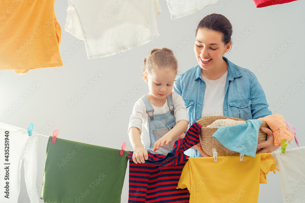 妇女和女孩把衣服挂在绳子上