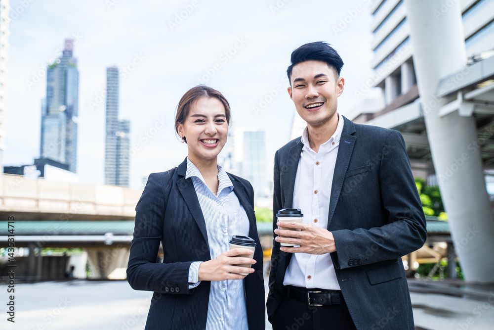 亚洲商人和女人在城市里拿着咖啡杯的肖像