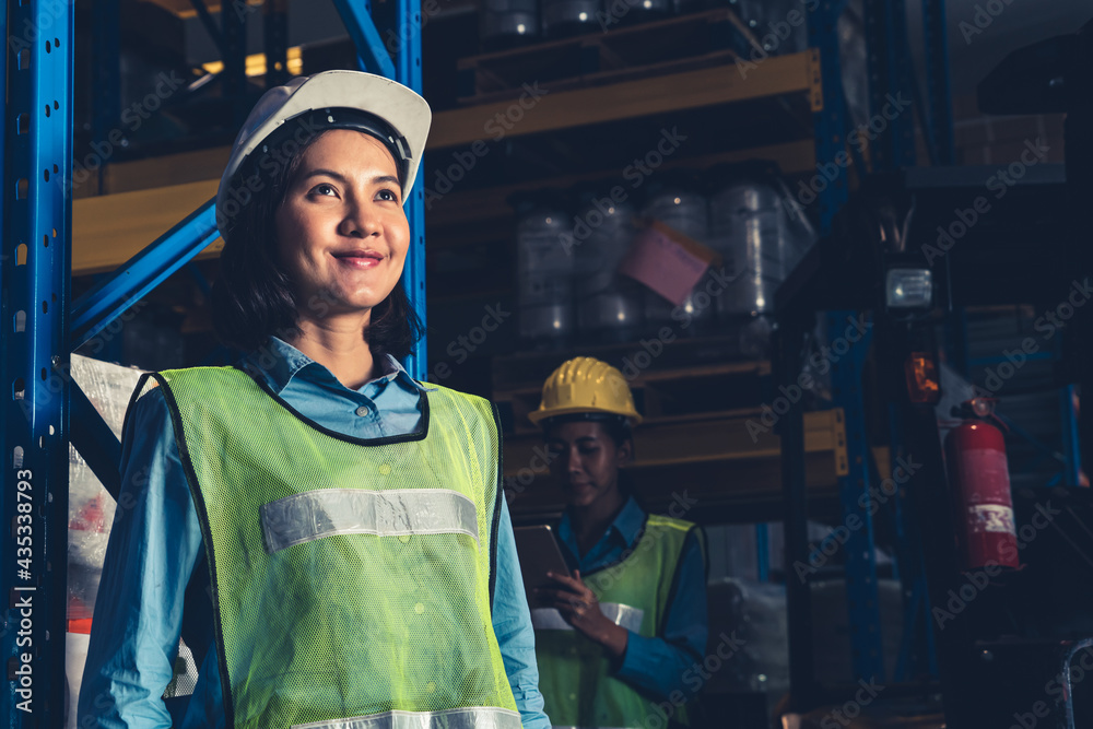 Portrait of young Asian woman warehouse worker smiling in the storehouse . Logistics , supply chain 