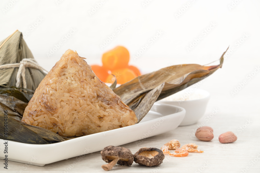 Zongzi. Rice dumpling for Dragon Boat Festival on bright wooden table background with ingredient.