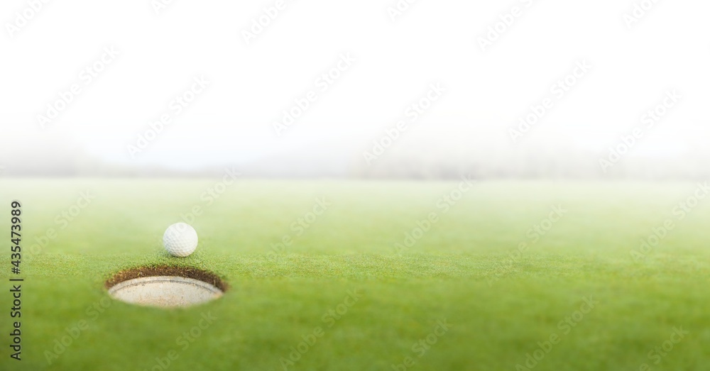 Composition of golf ball on golf course over white blur