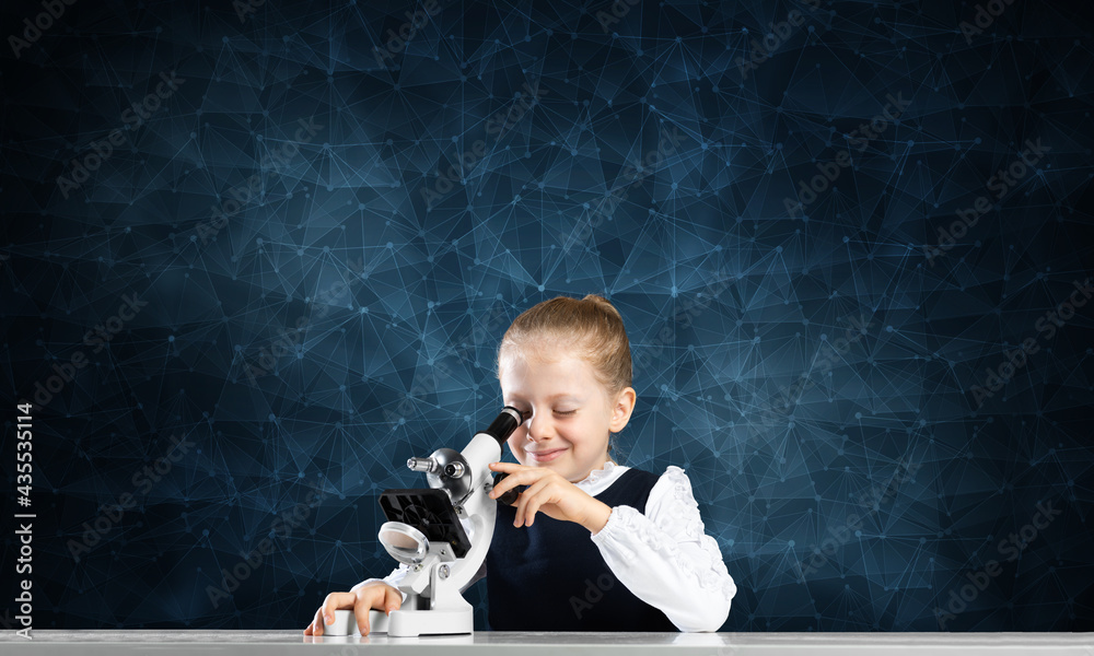 Little scientist looking through microscope