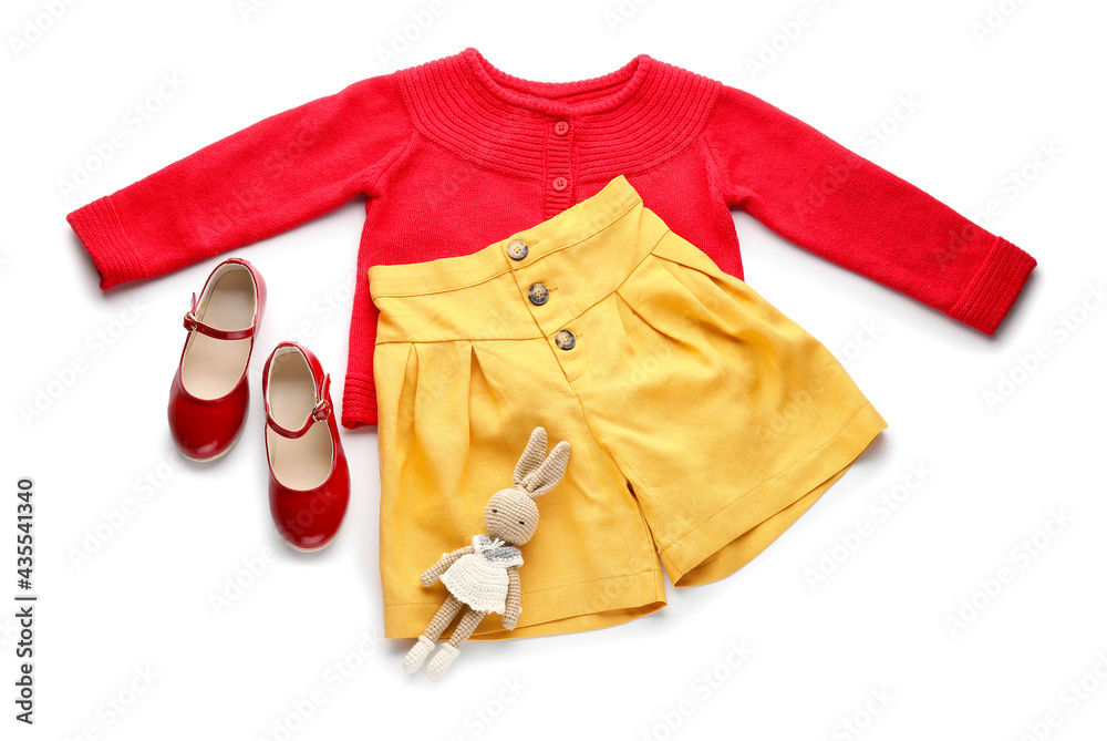 Childrens clothes and toy on white background