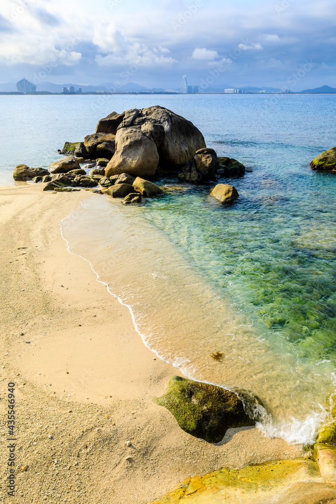 海滩、大海和蓝天上美丽的云朵的景观。海滩上的岩石。