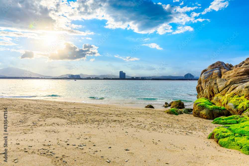 海滩、大海和蓝天上美丽的云朵的景观。海滩上的岩石。