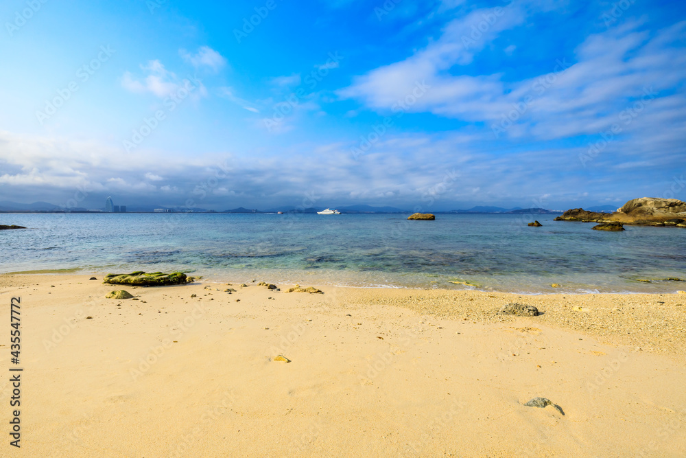 海滩、大海和蓝天上美丽的云朵的景观。海滩上的岩石。