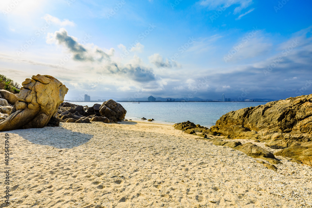 海滩、大海和蓝天上美丽的云朵的景观。海滩上的岩石。