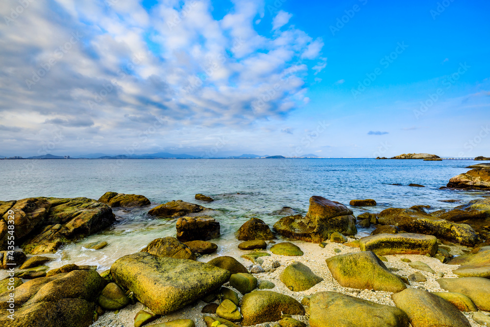 Landscape with beach,the sea and the beautiful clouds in the blue sky.rocks on the beach.