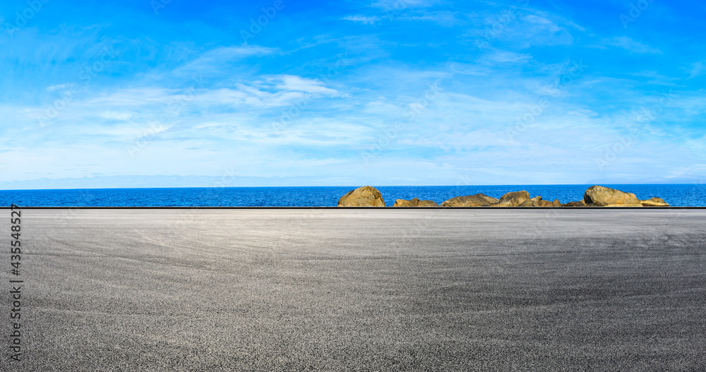 Asphalt road and beautiful seaside scenery under blue sky.