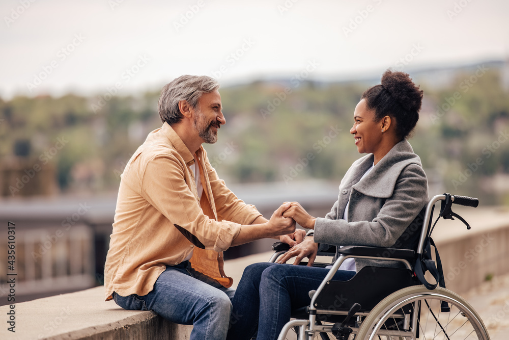 Adult lovers, holding hands, disability woman with her man.