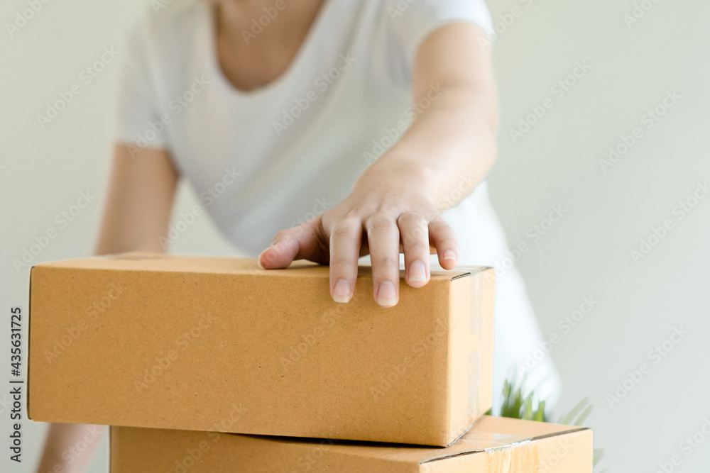 Asian business owner working at home with packing box of her online store prepare to deliver product