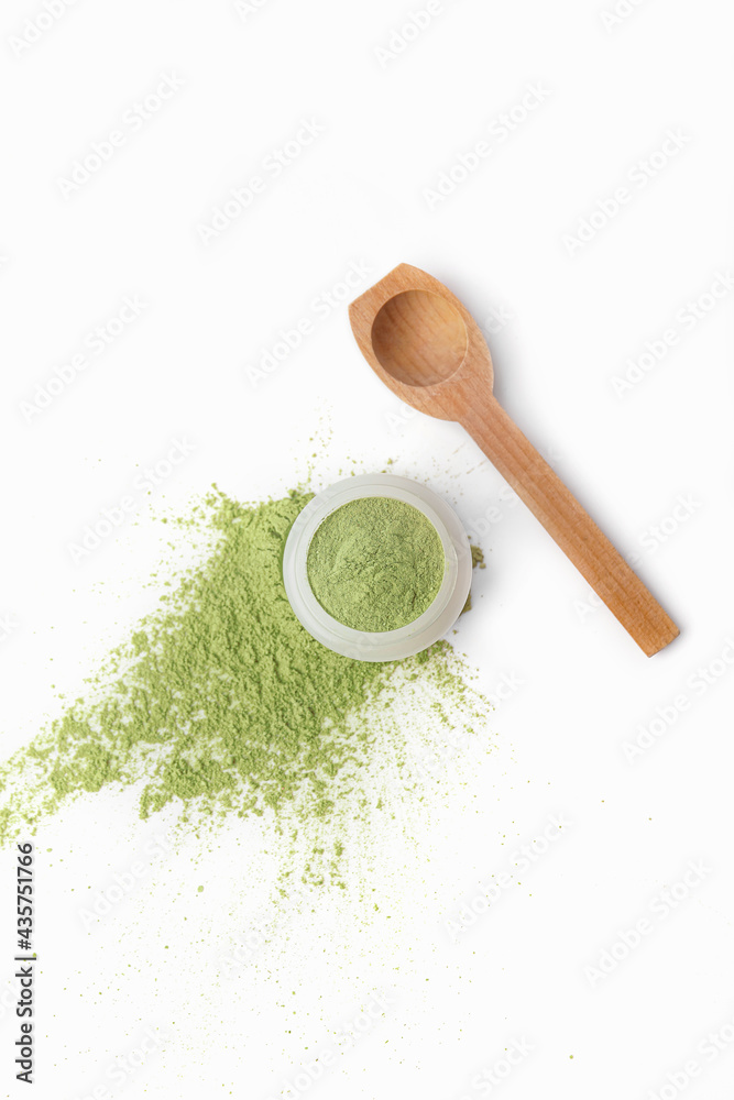 Jar and spoon with cosmetic clay on white background