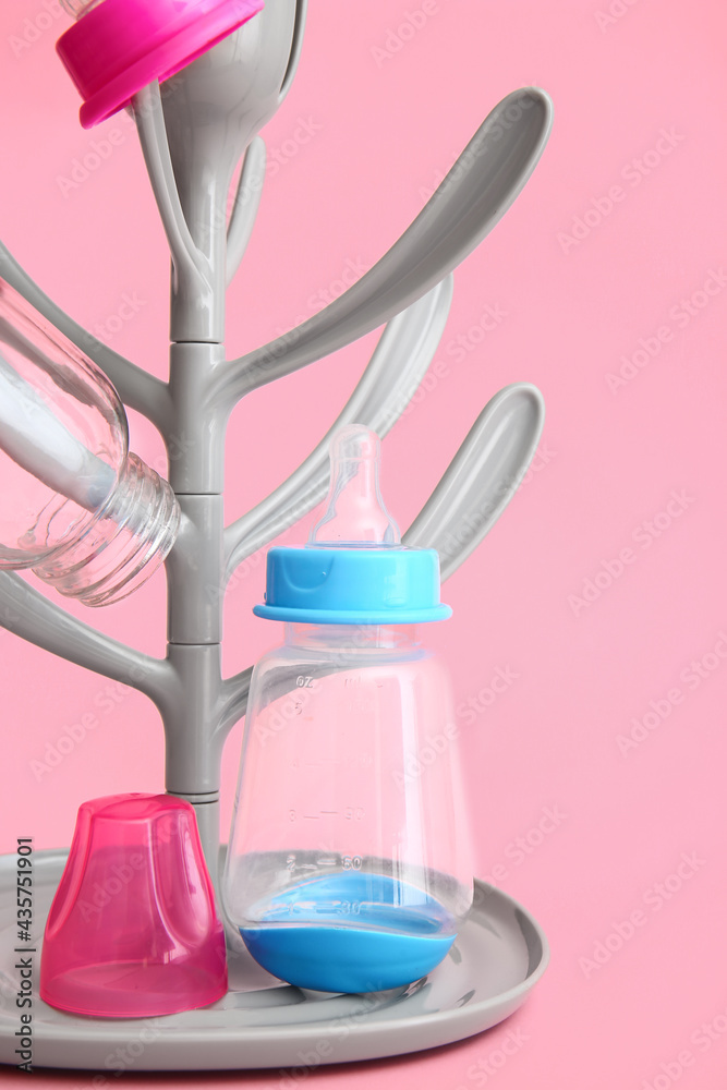 Drying rack for baby bottles on color background