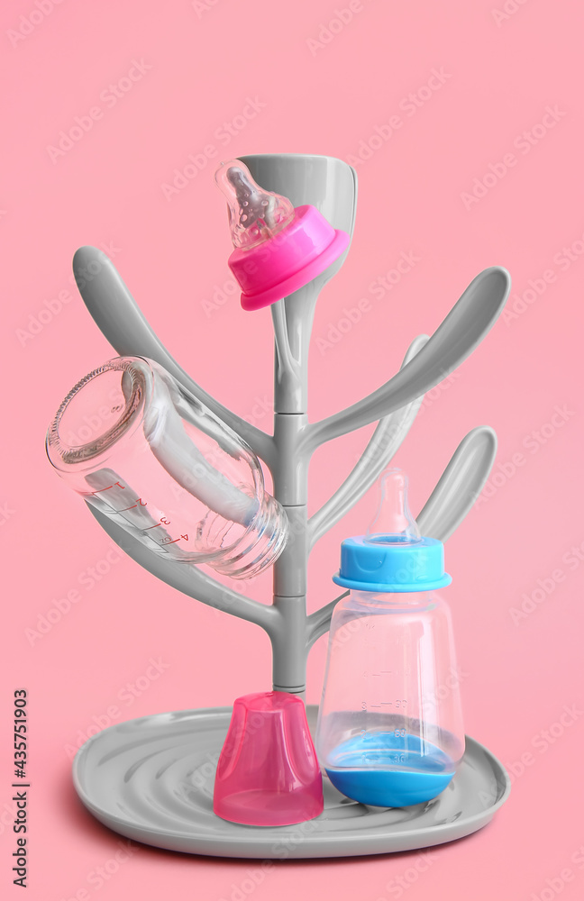 Drying rack for baby bottles on color background