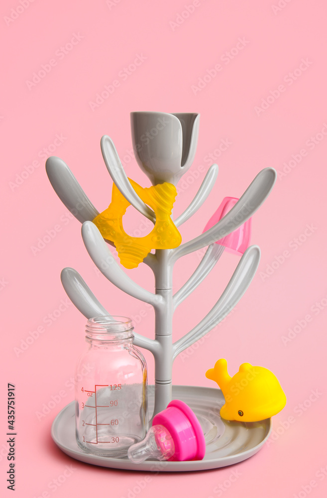 Drying rack for baby bottles on color background